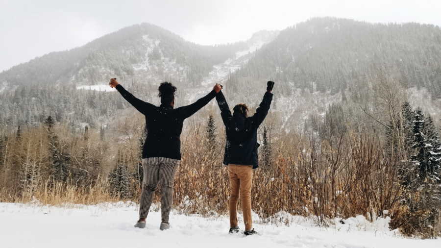 Woman who gave her son up for adoption at birth stands holding his hands in air while snow falls