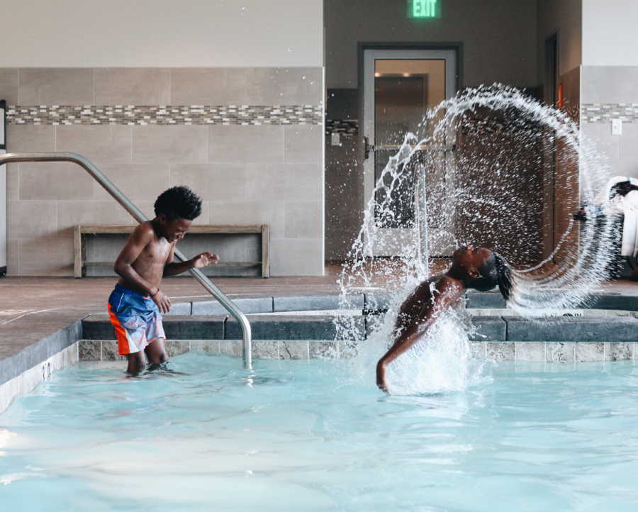 Boy who was adopted at birth flips hair in indoor pool while biological brother stands watching