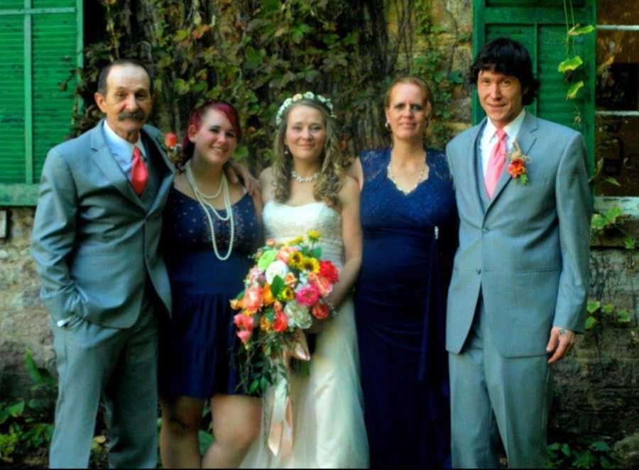 Bride stands beside, father, step sister, step mother, and brother on her wedding day