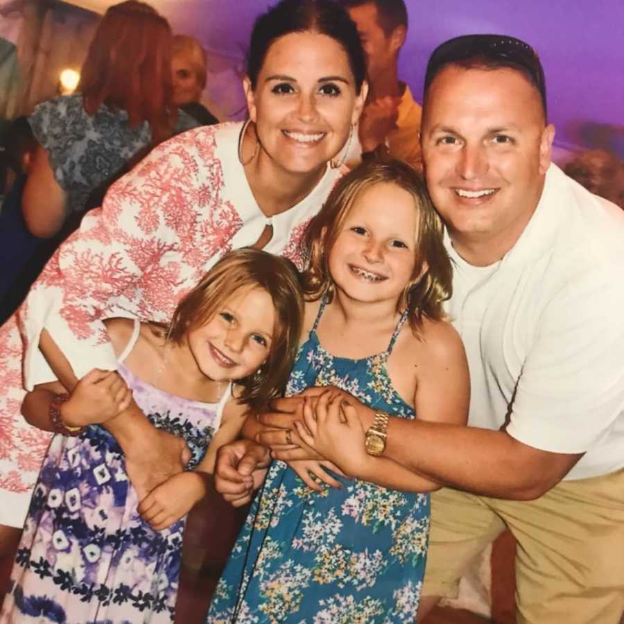 Husband who went into cardiac arrest at gym smiles beside wife and their two daughters