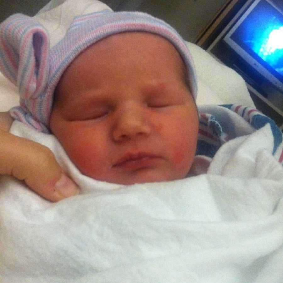 Close up of newborn girl sleeping with hat on