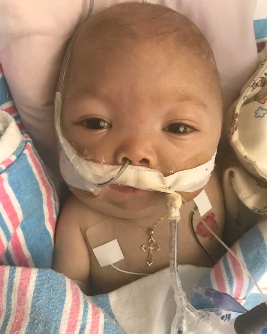 Baby with HLH in emergency room with gold cross necklace around his neck