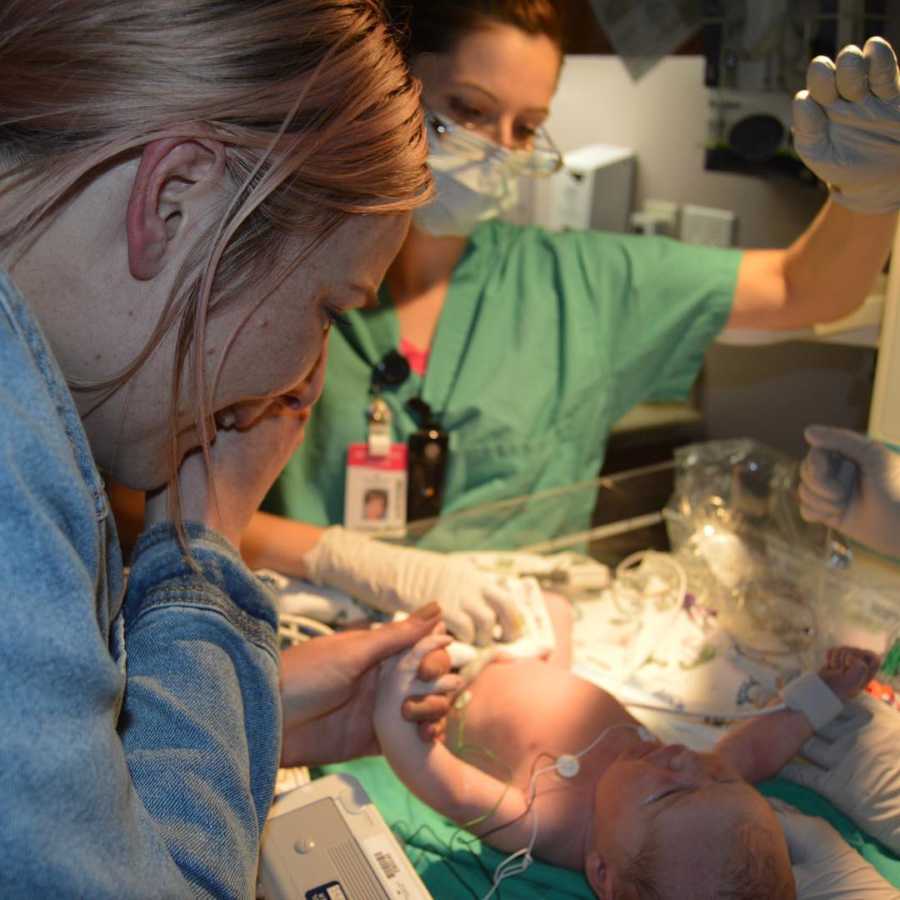 Mother smiles as she looks at her adopted newborn in hospital 