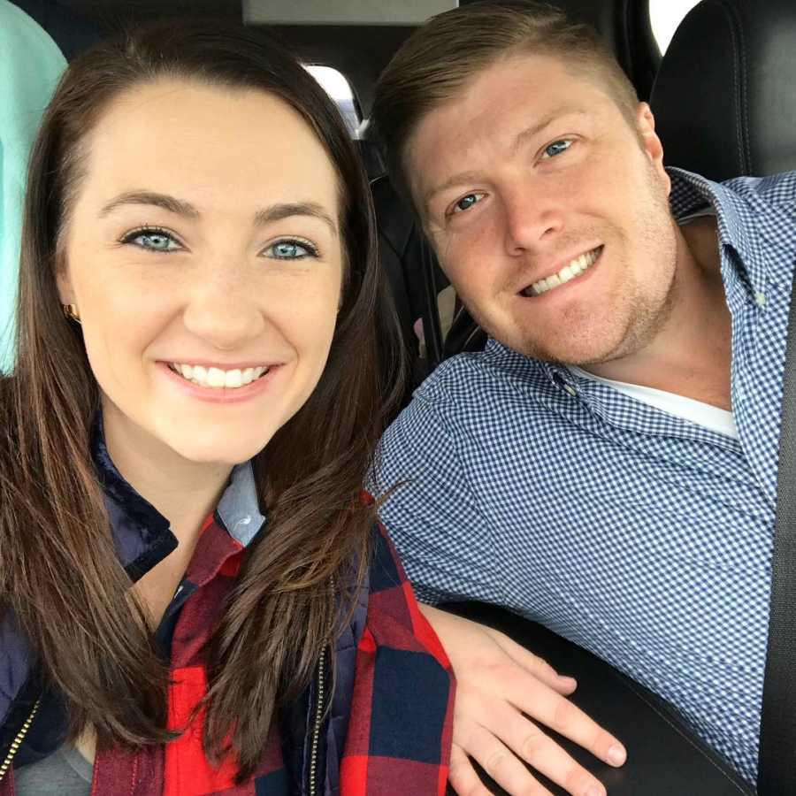 Husband and wife who are going to adopt a child smile in selfie in car