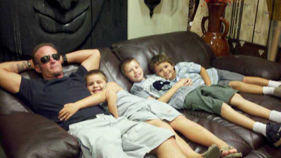 Father who has since passed from drinking energy drink sits on couch with three sons