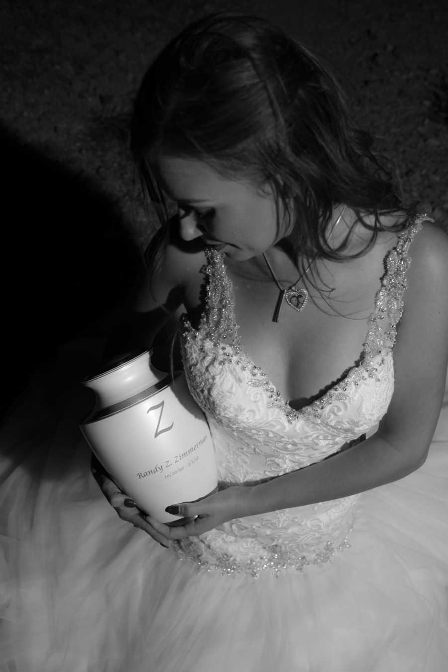 Woman in wedding gown sits holding urn of late fiancee's ashes