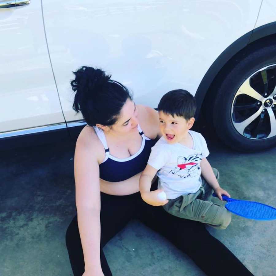 Mother who told her son not to eat crap or he'll get fat sits on driveway by car with son sitting in her lap