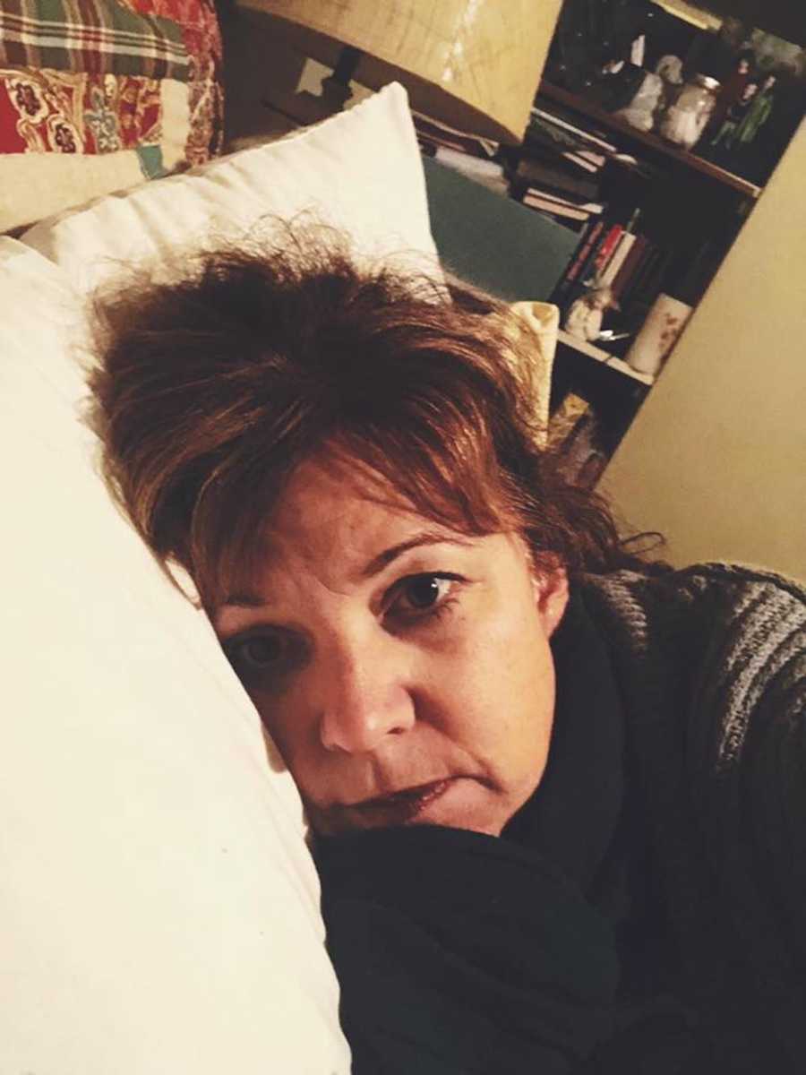 Mother who is exhausted after day with kids takes selfie in bed