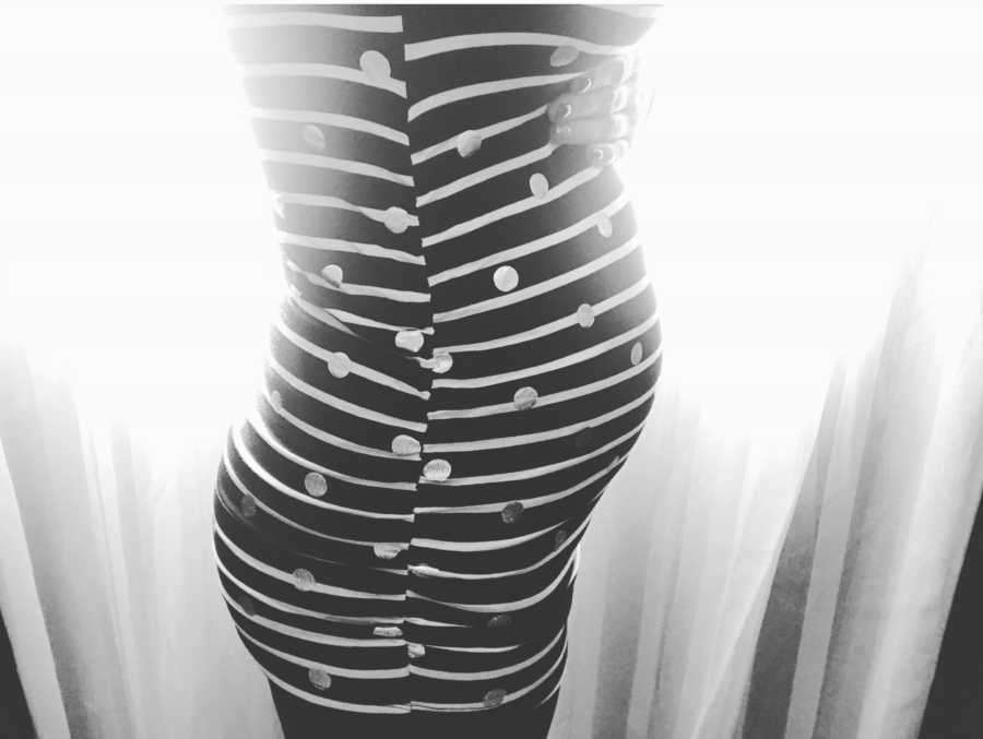 Side view of pregnant woman in striped dress with polka dots