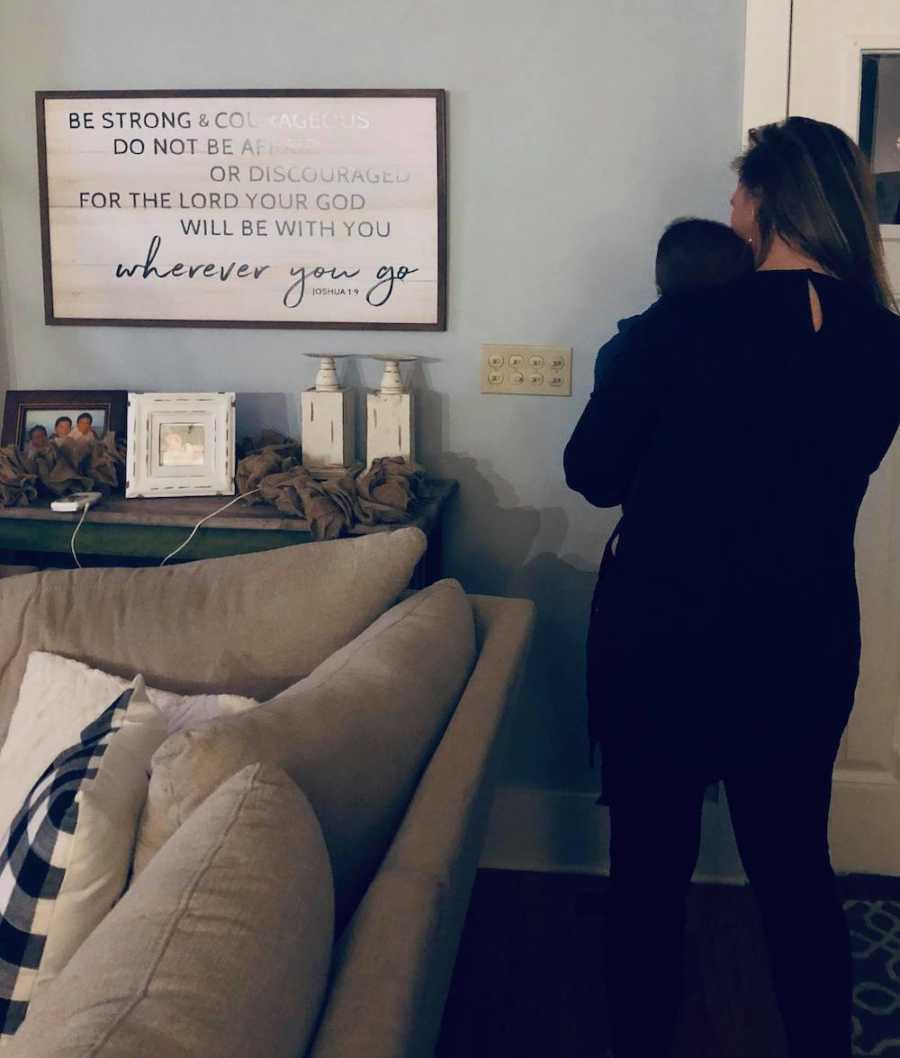 Woman stands beside couch in home holding baby she has had for 146 days