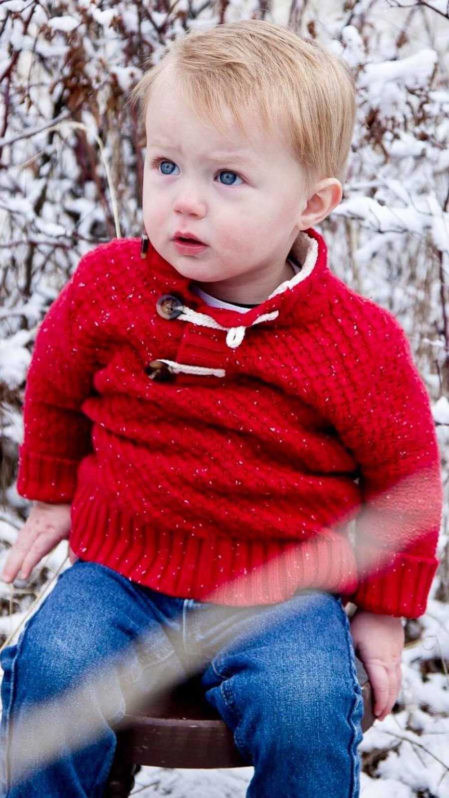 Little boy sitting on stool in front of snowy plant who was poisoned by drinking baby oil