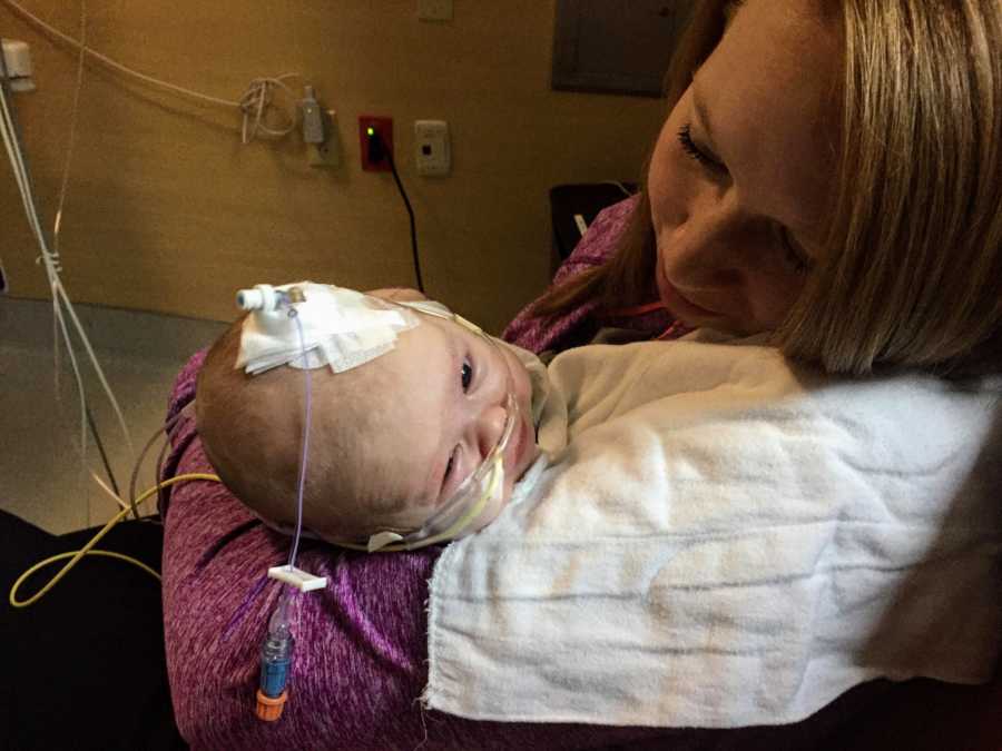 Mother sits in hospital holding baby daughter who has RSV