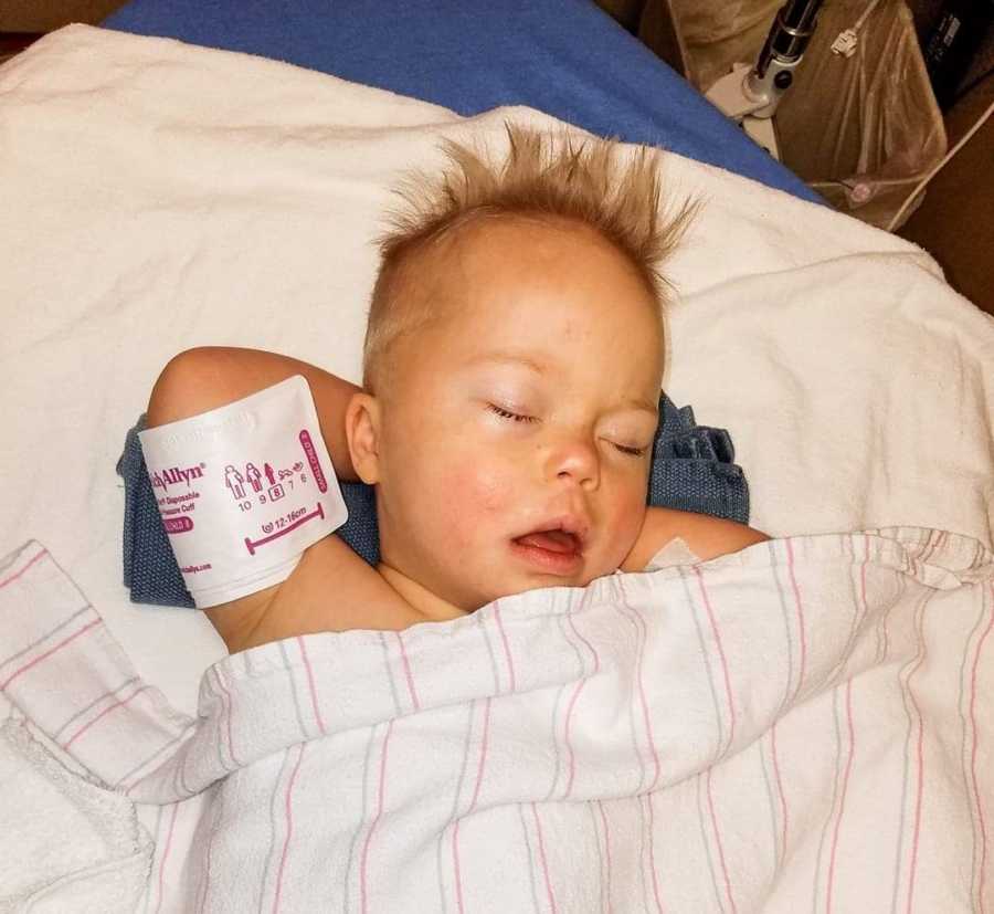 Little boy with down syndrome and cancer laying asleep in hospital bed 