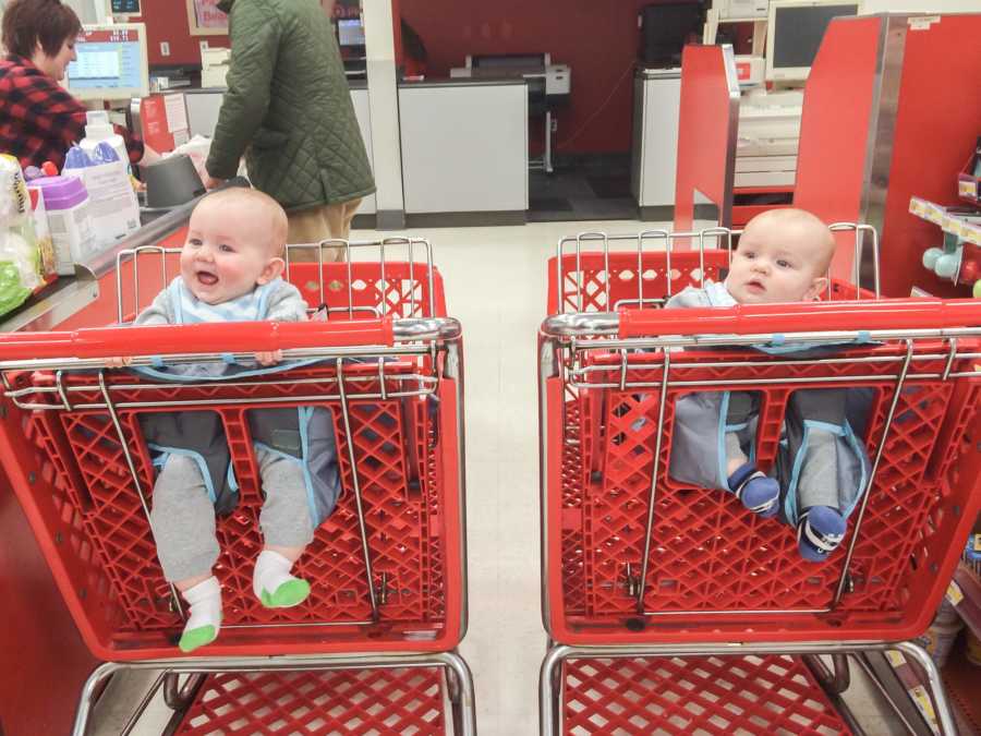 Target shopping carts side by side at checkout with a baby sitting in each cart