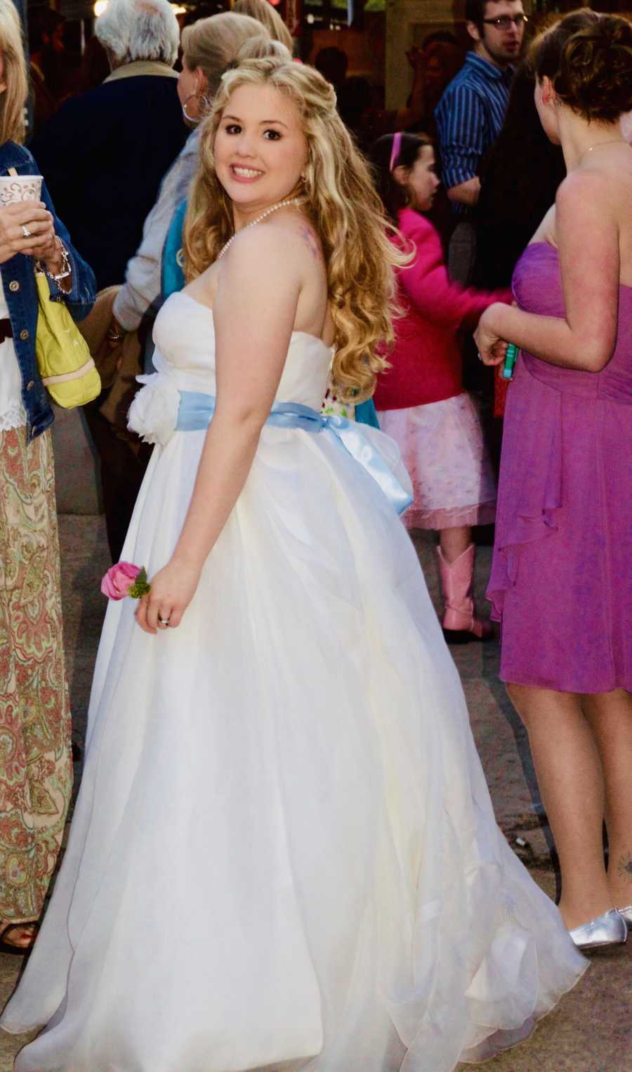 Bride smiles looking over her shoulder at her wedding reception