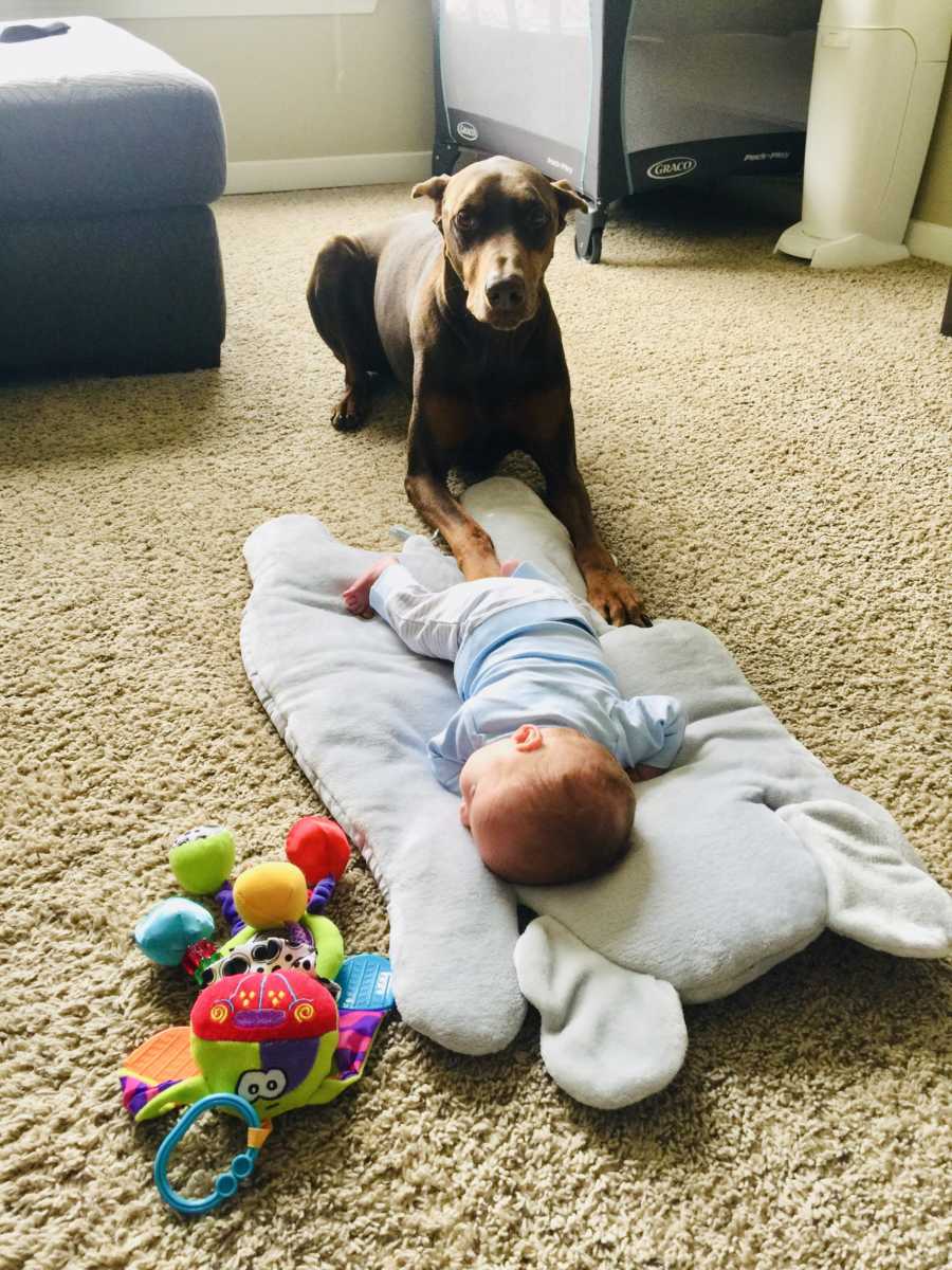 Baby boy lays asleep on floor while dog lays next to him