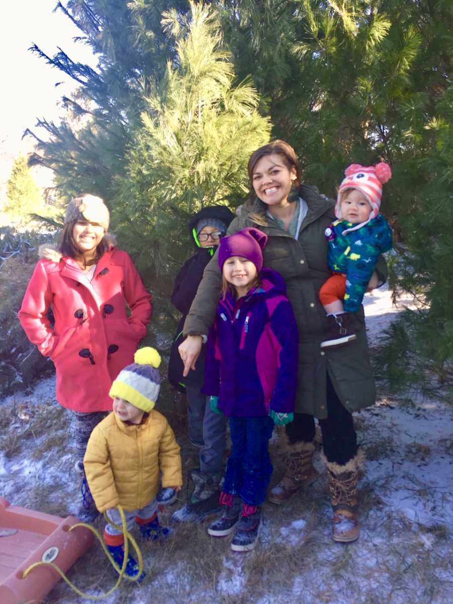 Mother stands outside with five adopted kids dressed for snow