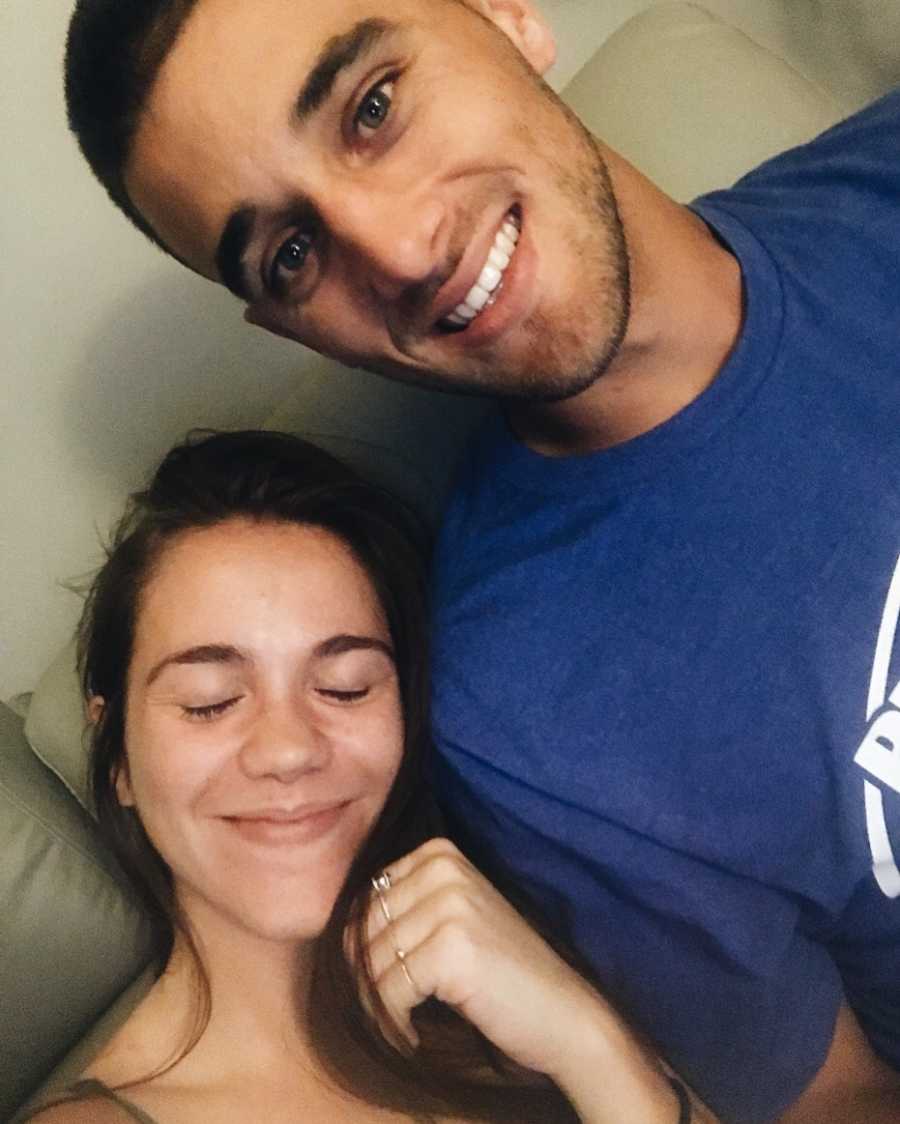 Single mother smiles in selfie while resting her head on boyfriend's shoulder