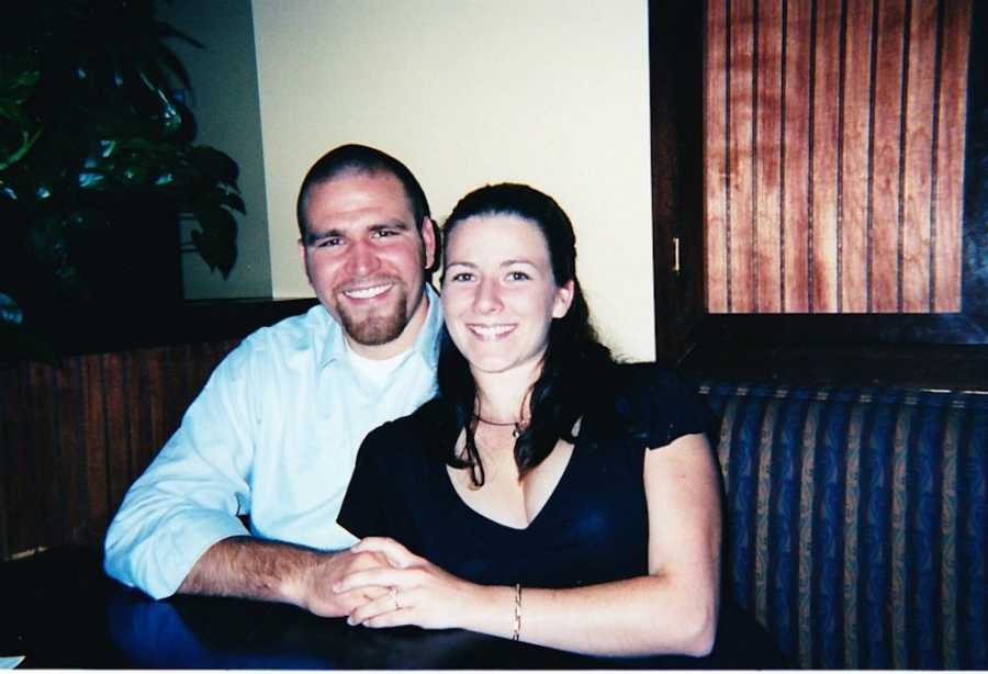 Husband and wife sit beside each other smiling at restaurant table