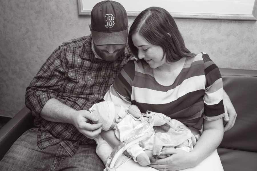 Mother and father sit on couch holding baby in NICU who they would never bring home