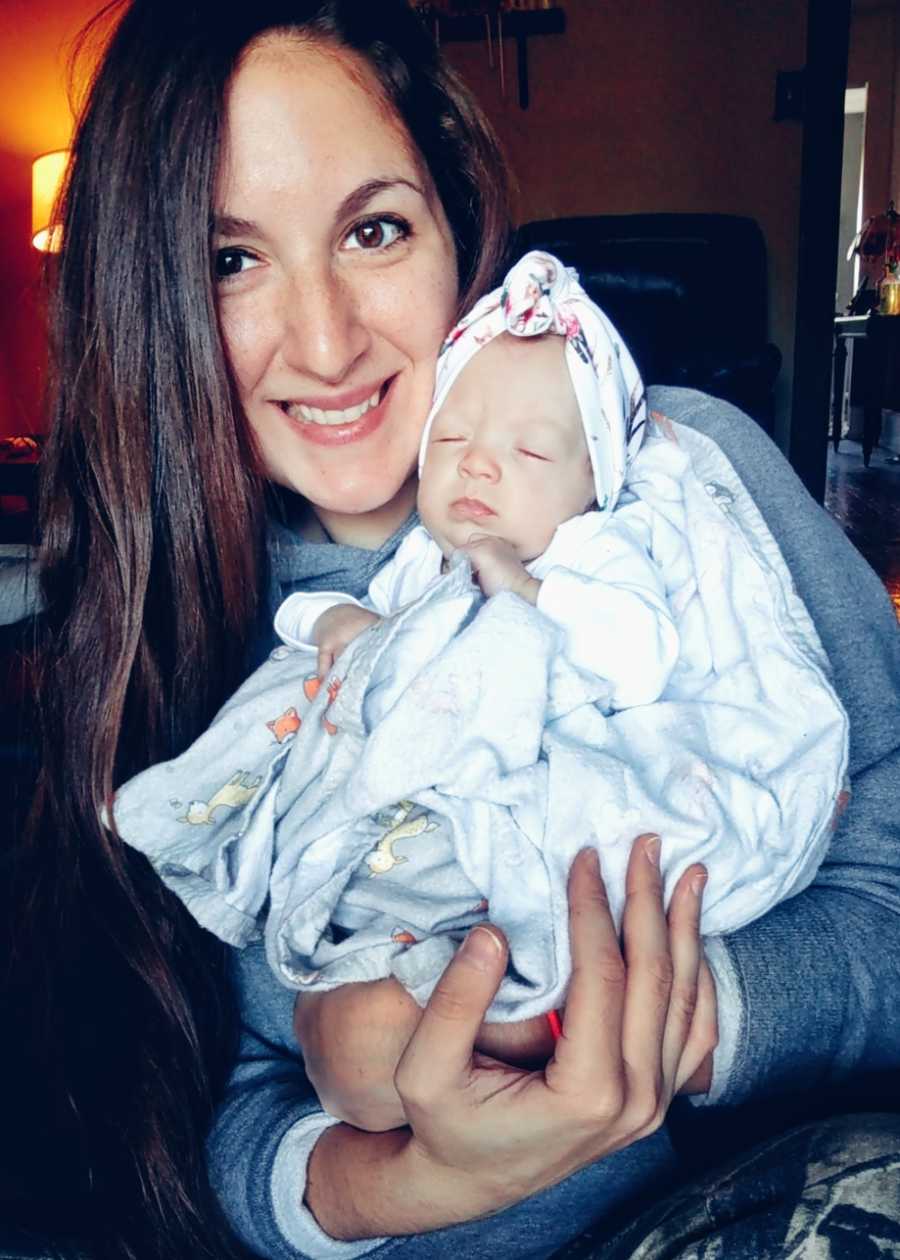 Mother smiling holding baby at home after being in NICU for 36 days