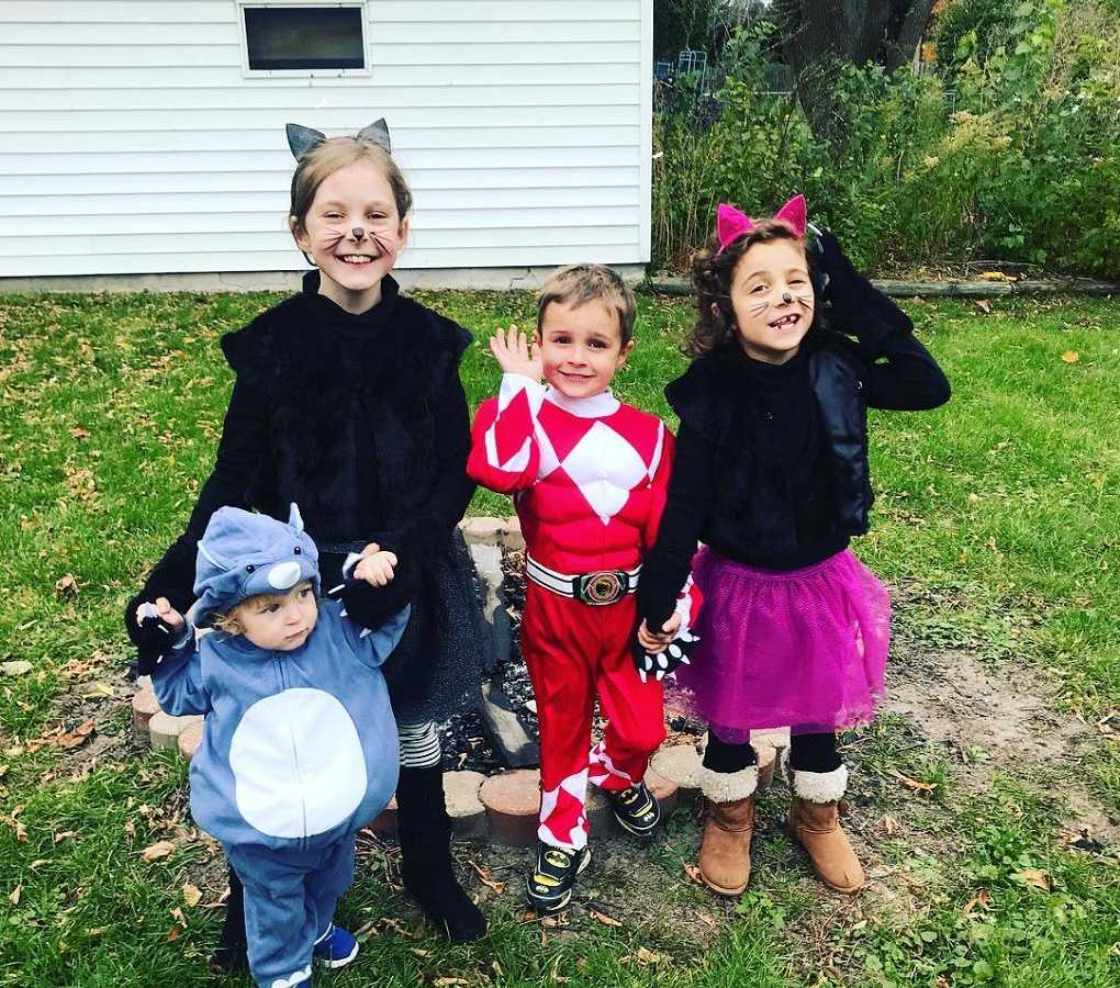 Siblings standing in yard dressed in costumes for Halloween