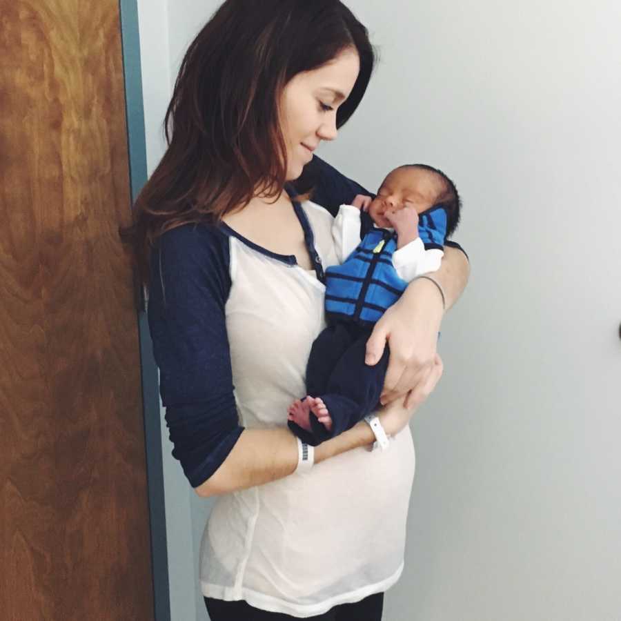 Mother stands holding baby boy that was conceived in rape