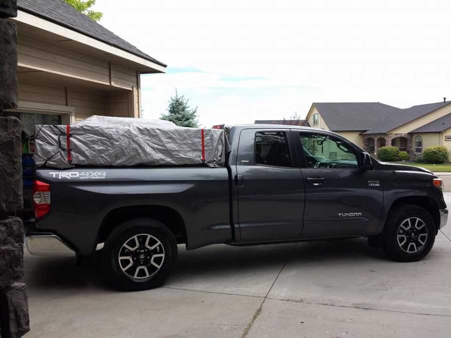 Truck in driveway and bed is covered with tarp