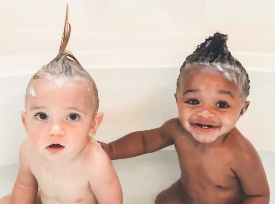 Adopted newborns sit in bathtub with hair slicked up with soap