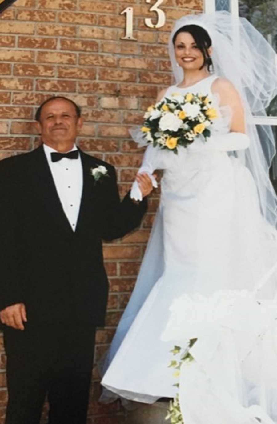 Woman on her wedding day holding hands with father who has since passed away