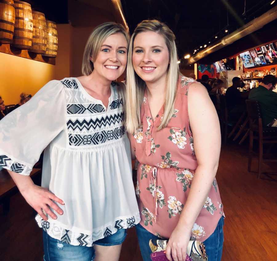 Woman who struggles to get pregnant stands with arm around her egg donor in restaurant