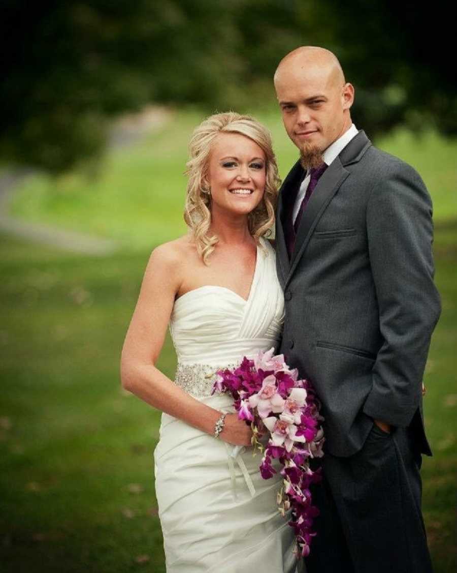 Bride and groom smile arm in arm outside