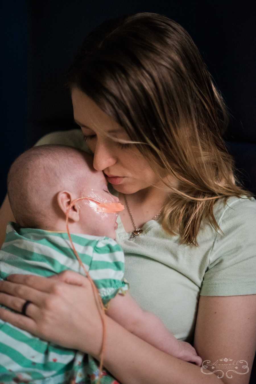 Mother holds baby, who was on life support for two weeks, close to her chest