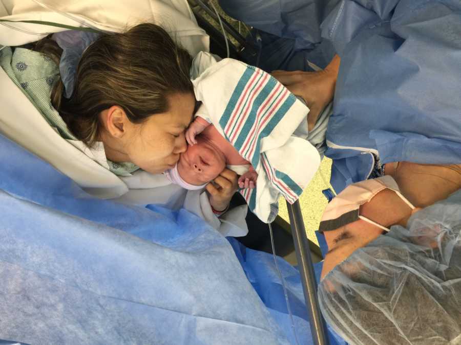 Mother stands holding adopted baby beside biological mother who had c-section