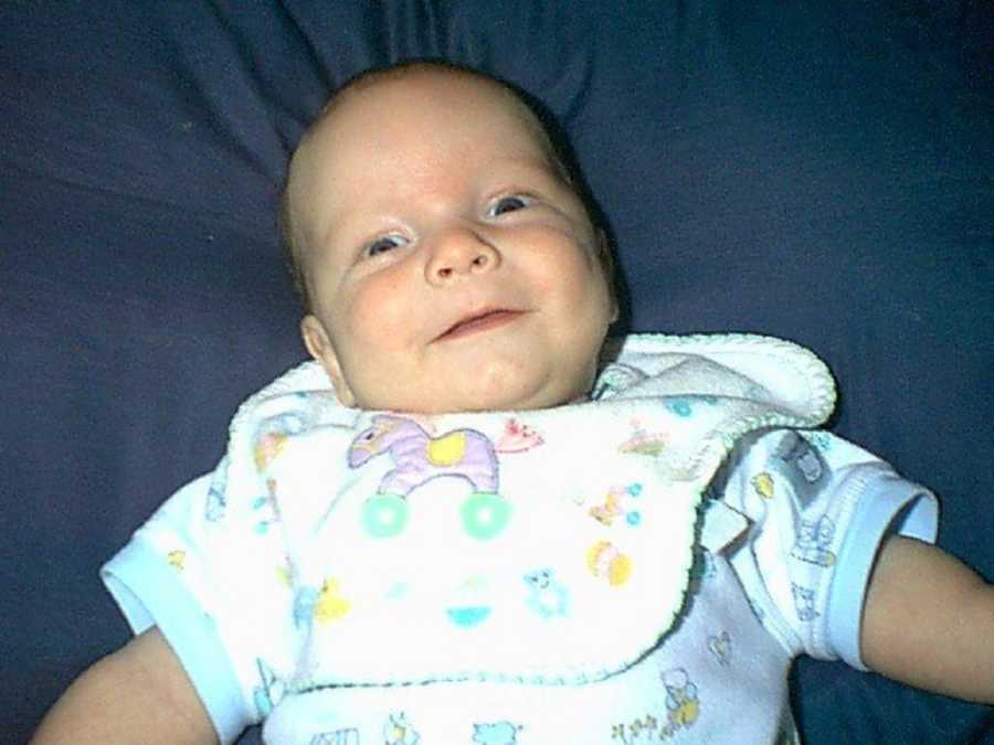 Baby laying on his back smiling before going through shaken baby syndrome