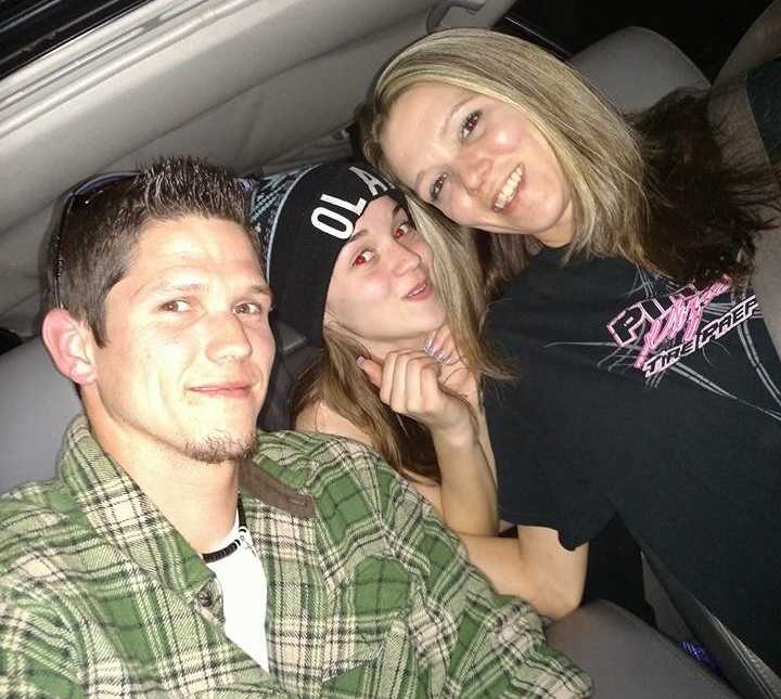 Woman smiles in car with her brother who struggles with addiction and daughter who sits in back seat