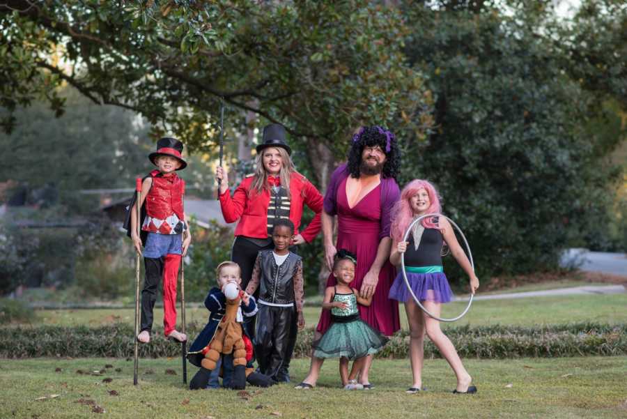 Family of seven stands outside dressed as characters from The Greatest Showman for Halloween
