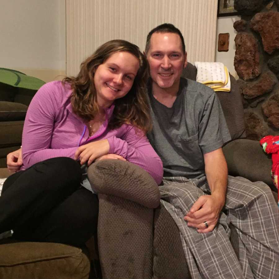 Woman sits on couch smiling beside father who has since passed away