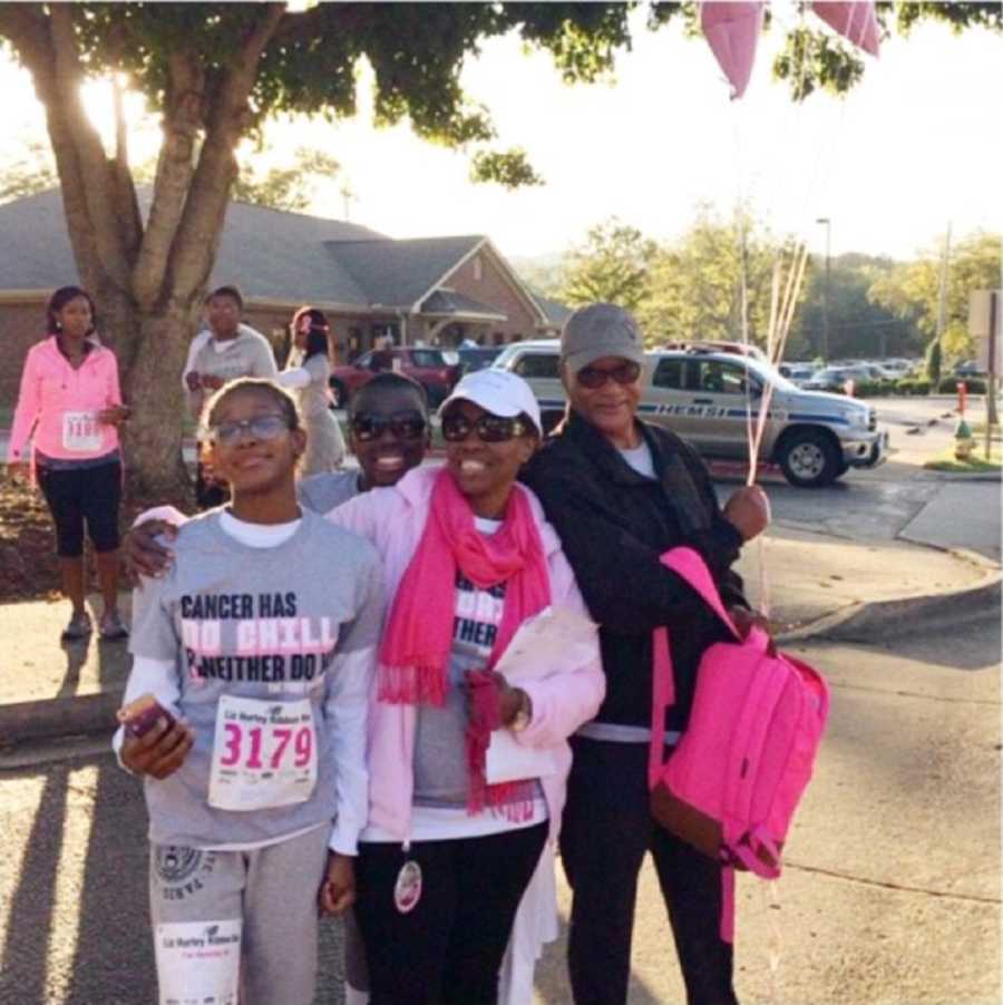 Young woman with breast cancer stands beside her mother with breast cancer, sister and father at breast cancer walk