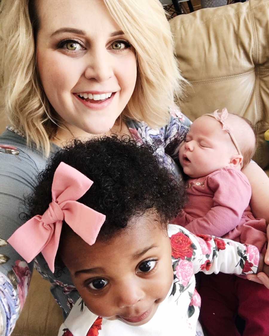 Mother smiles in selfie with adopted baby and biological baby