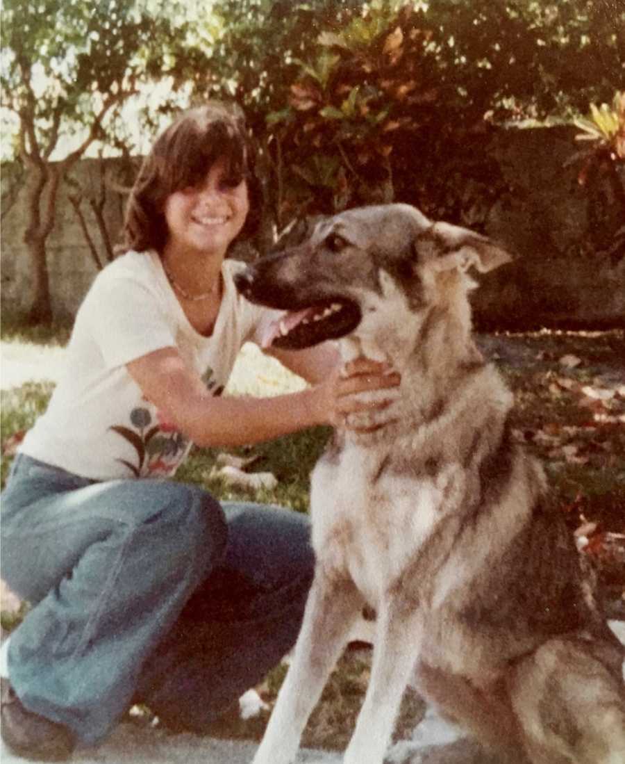 Teen who has terrible home life squats down petting big dog