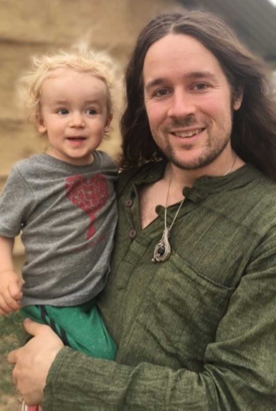 Man smiling as he holds son 
