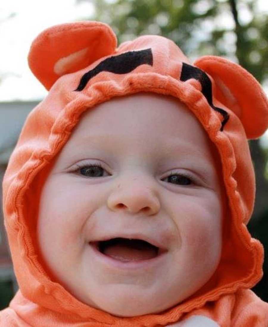 Baby smiles in Tigger Halloween costume