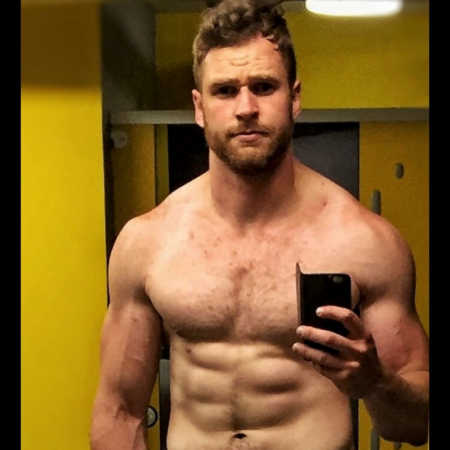 Fit man who once had body dysmorphia stands in locker room taking mirror selfie