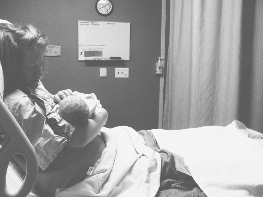 Woman lays in hospital bed holding her baby that she is giving up for adoption