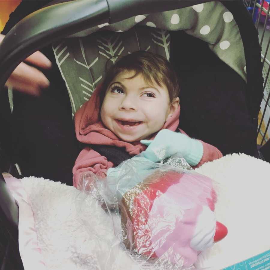 Baby with Lissencephaly sits smiling in car seat