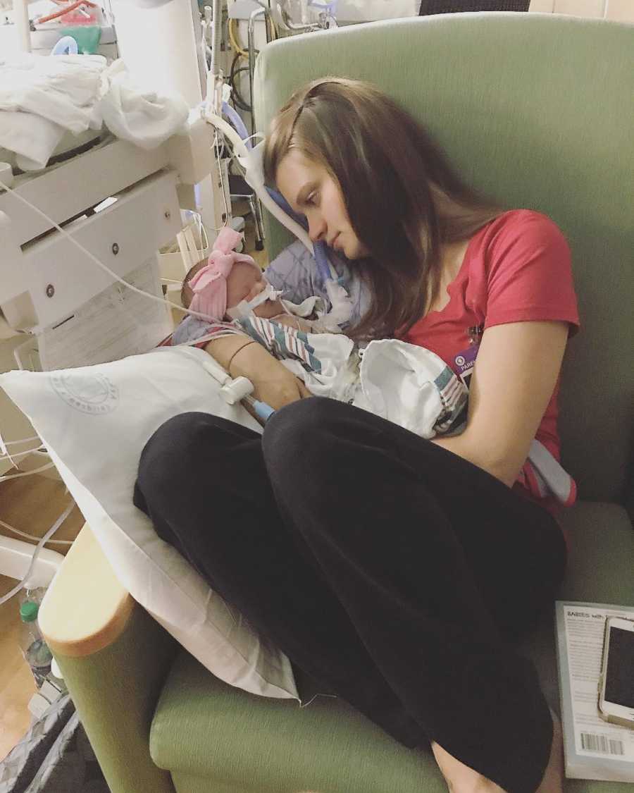 Mother sits on chair of NICU holding baby with PHTN