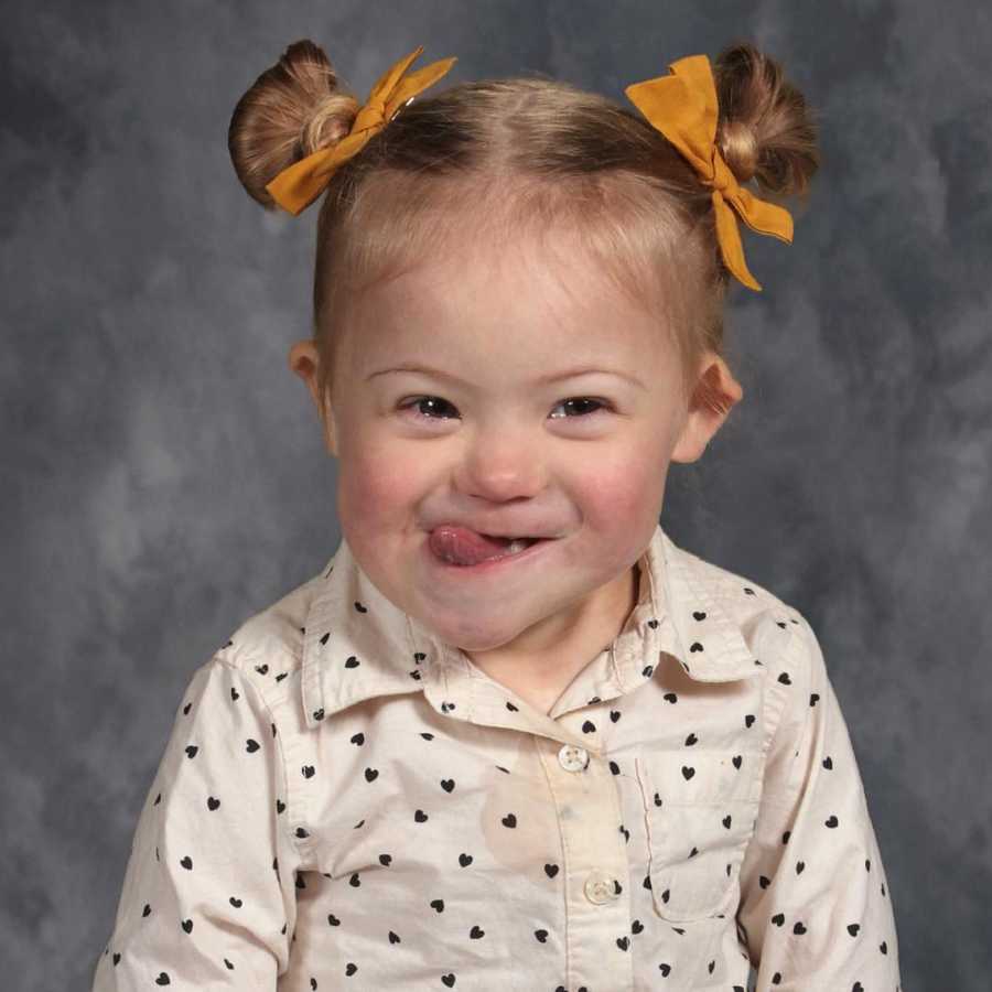 Little girl with down syndrome smiles for school picture