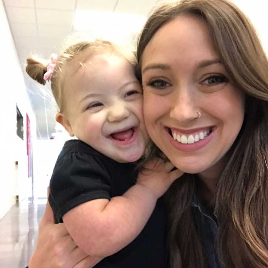 Mother smiles in selfie while she holds daughter with down syndrome