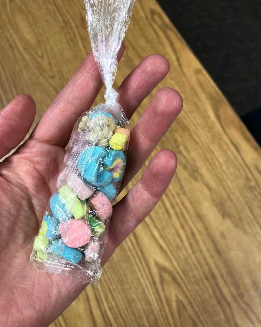 Hand holding plastic bag full of marshmallows from Lucky Charms student gave to teacher